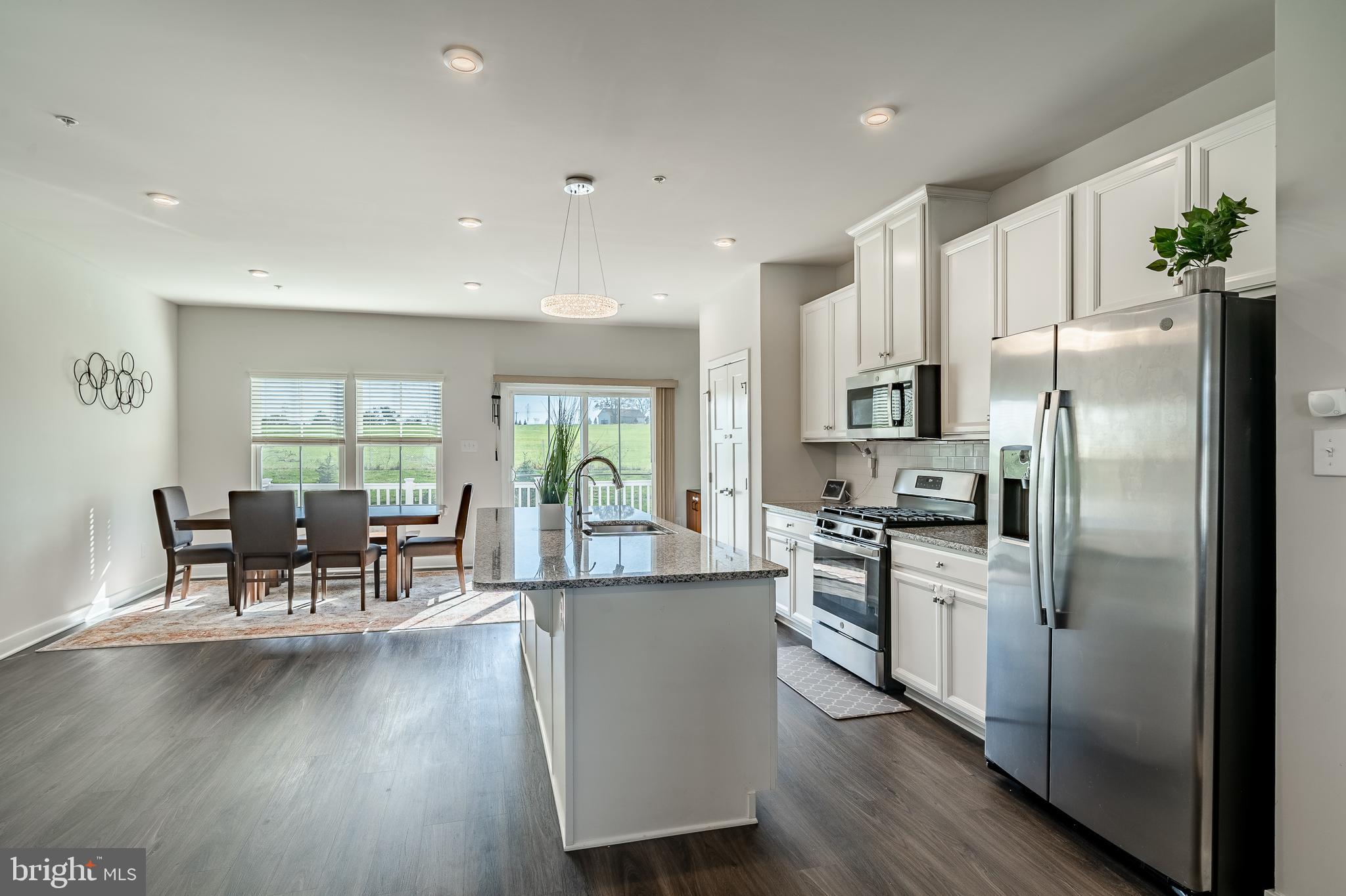 74 Glory Maple Lane Downingtown, PA 19335 - Photo 11 of 32 a kitchen with stainless steel appliances granite countertop a refrigerator a stove top oven a dining table and chairs with wooden floor