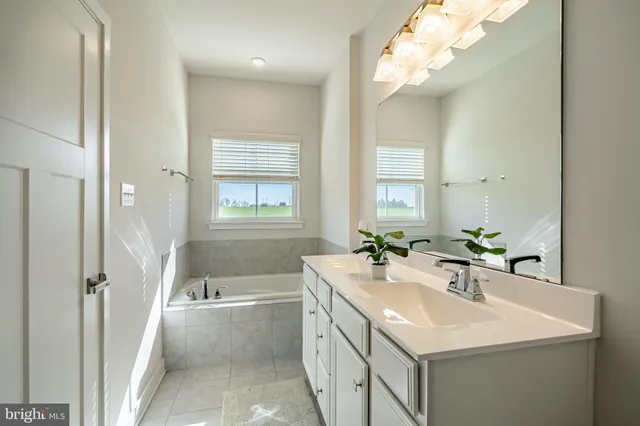 a bathroom with a sink a tub and a mirror