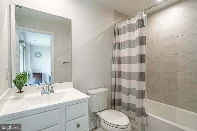 a bathroom with a sink a toilet a mirror a vanity and shower