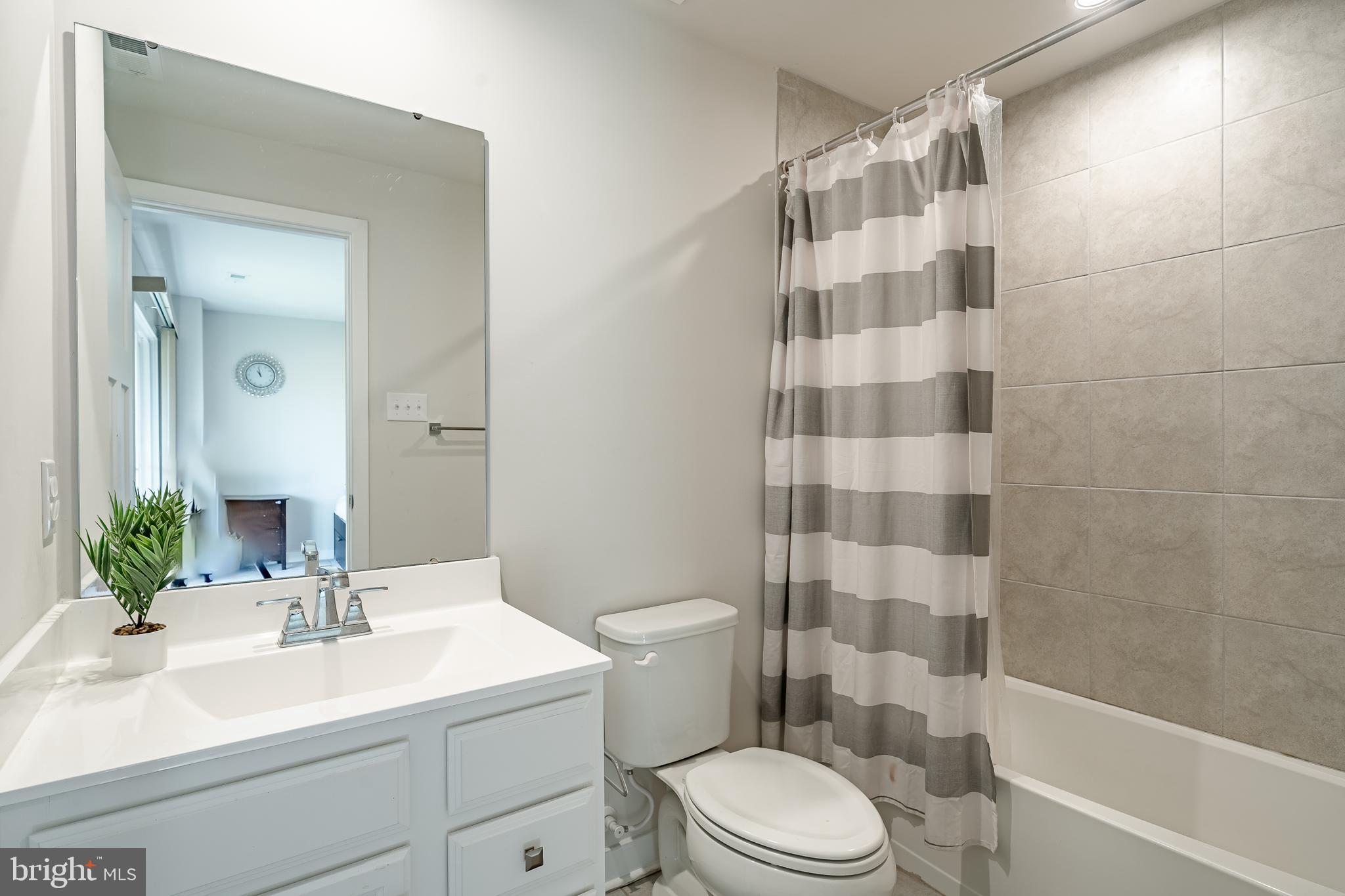 74 Glory Maple Lane Downingtown, PA 19335 - Photo 25 of 32 a bathroom with a sink a toilet a mirror a vanity and shower