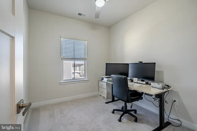 a view of a workspace with furniture and a window