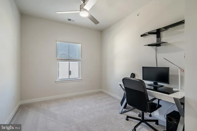a view of a workspace with furniture and a window
