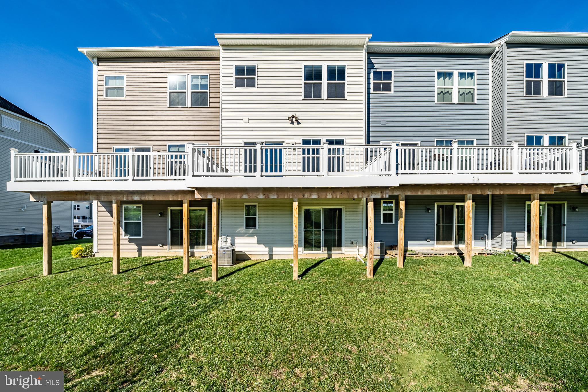 74 Glory Maple Lane Downingtown, PA 19335 - Photo 31 of 32 a view of a white house with large windows and a yard