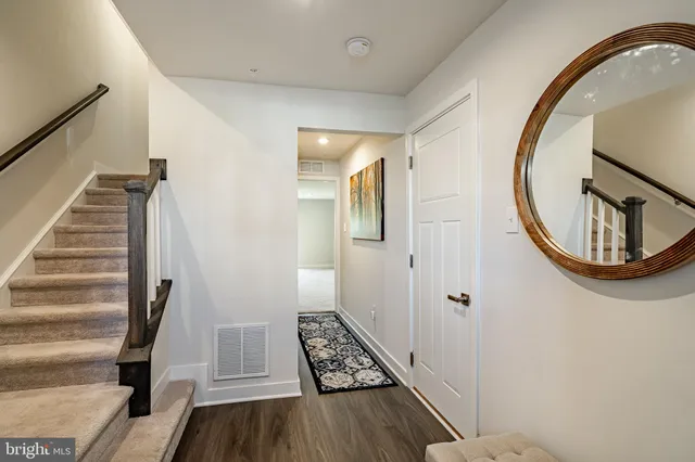 a view of a hallway with wooden floor and entryway