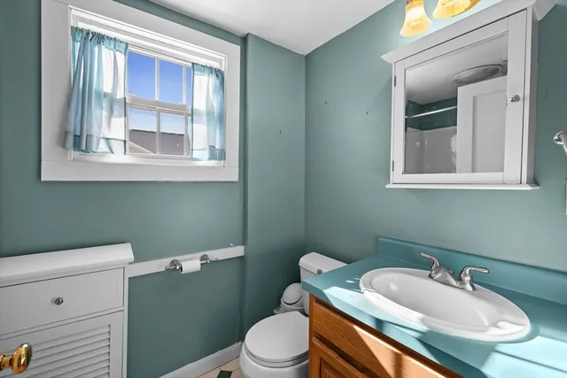 a bathroom with a toilet sink and mirror