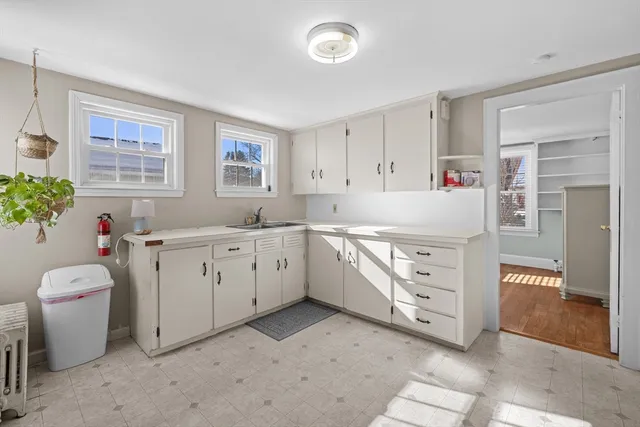 a kitchen with a sink cabinets and wooden floor