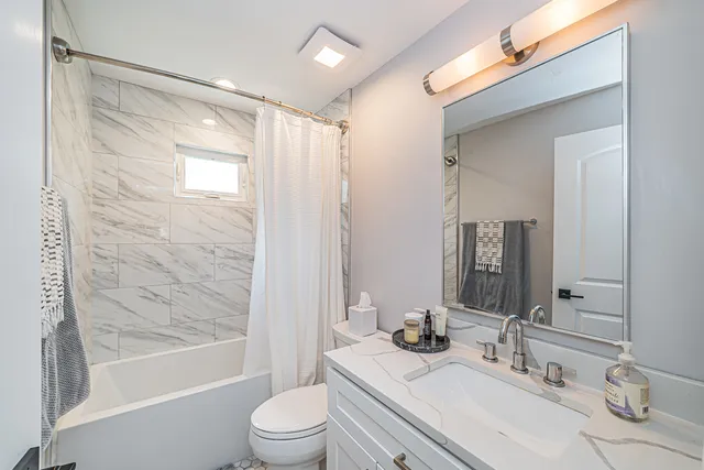 a bathroom with a granite countertop sink toilet and shower
