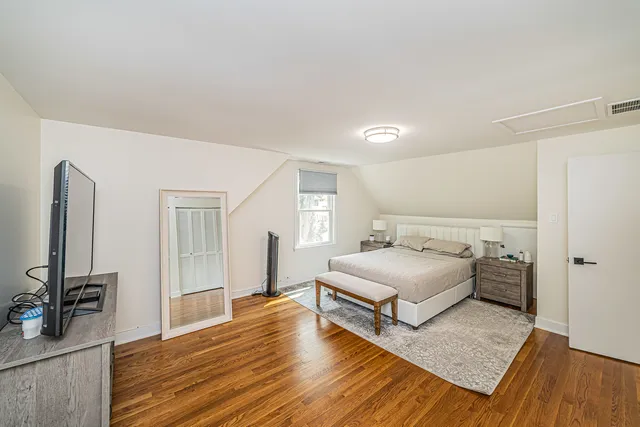 a bedroom with a bed and wooden floor