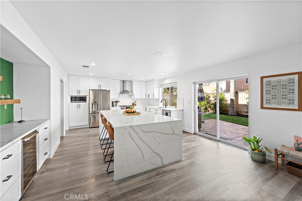 4314 Silver Spring Way Oceanside, CA 92057 - Photo 13 of 49 a large kitchen with stainless steel appliances a large counter top a stove a refrigerator white cabinets and wooden floor