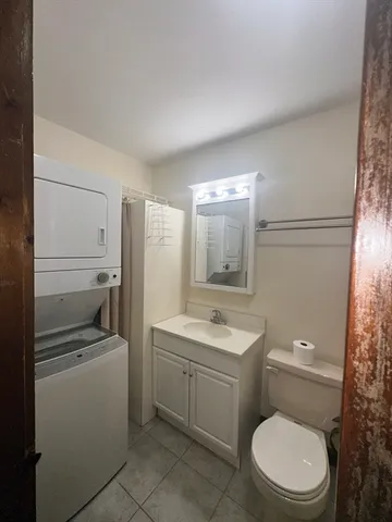a bathroom with a toilet a sink a tub and mirror