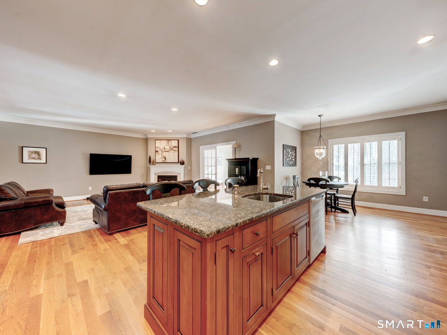 254 Sunset Ridge Rocky Hill, CT 06067 - Photo 10 of 40 a open kitchen with stainless steel appliances granite countertop a stove top oven a dining table and chairs with wooden floor