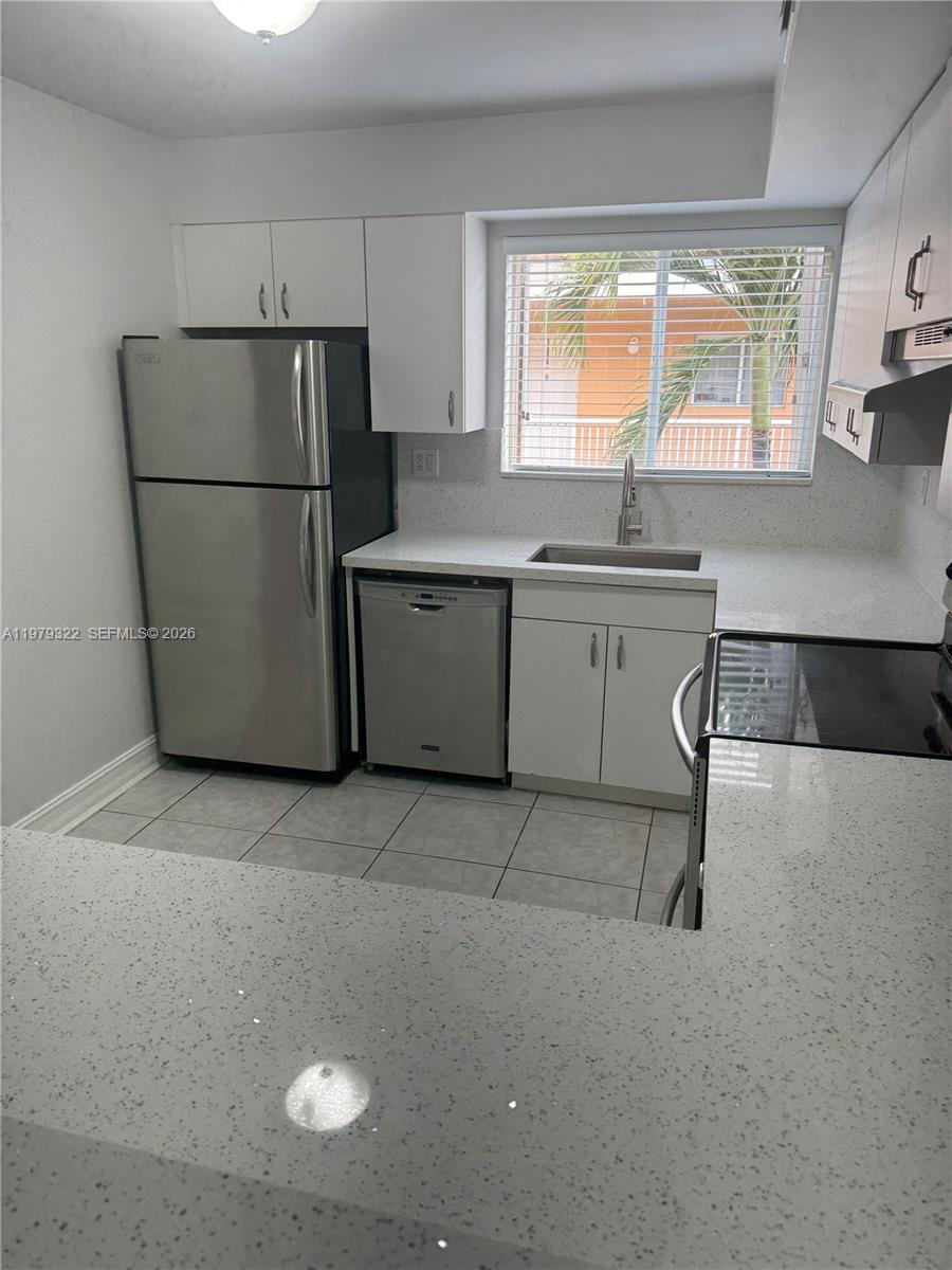 14909 Southwest 80th Street, Unit 216 Miami, FL 33193 - Photo 2 of 16 a kitchen with a refrigerator a sink and a stove