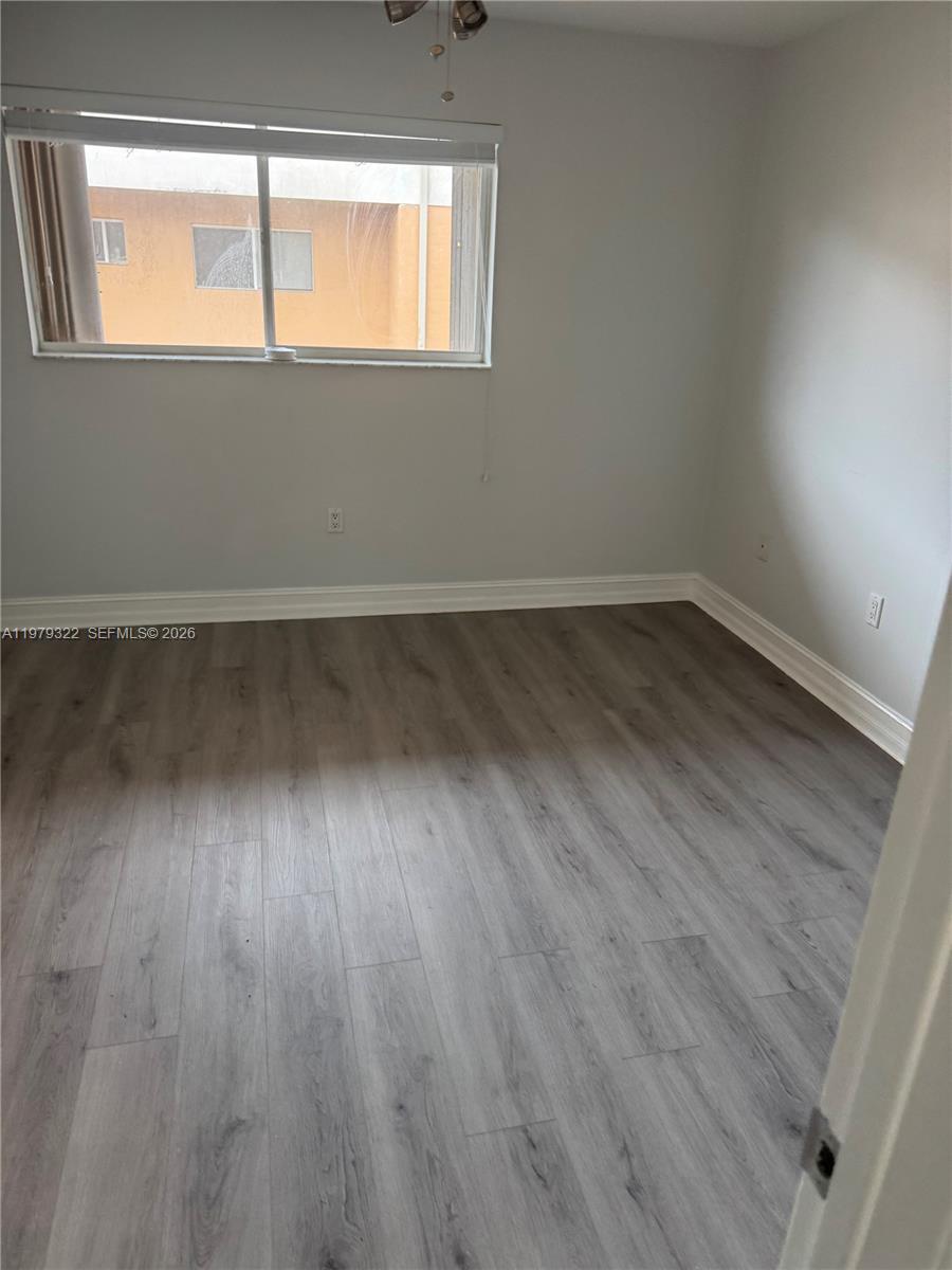 14909 Southwest 80th Street, Unit 216 Miami, FL 33193 - Photo 7 of 16 a view of an empty room and wooden floor and a window