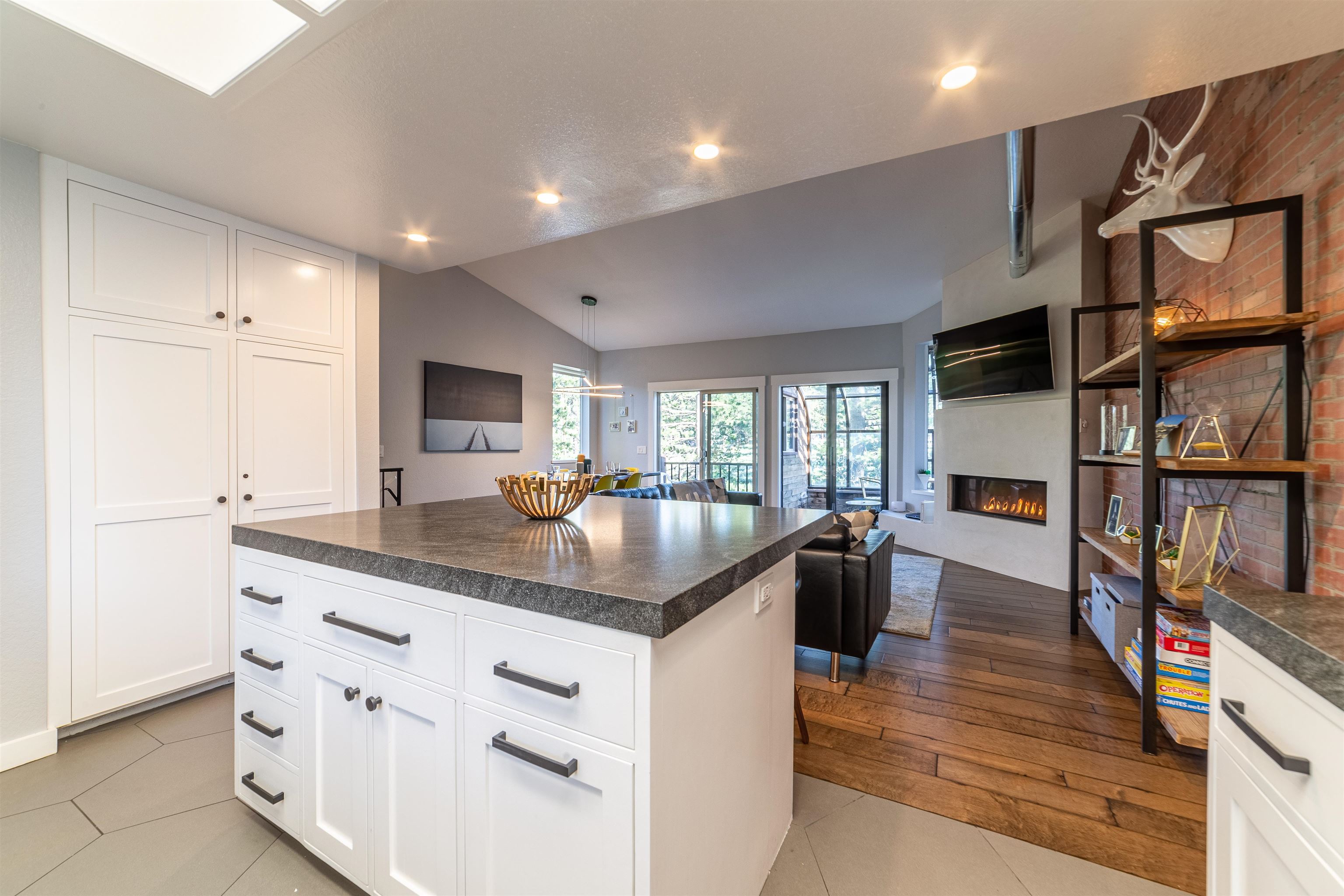 384 Joaquin Road, Unit 31 Mammoth Lakes, CA 93546 - Photo 27 of 29 Kitchen featuring dark countertops, a large fireplace, open floor plan, recessed lighting, and white cabinets