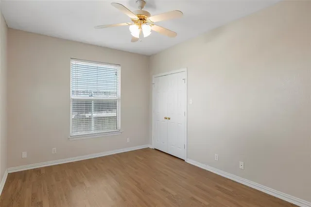 an empty room with a window and a fan