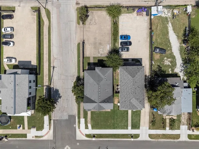 an aerial view of residential houses with outdoor space and parking