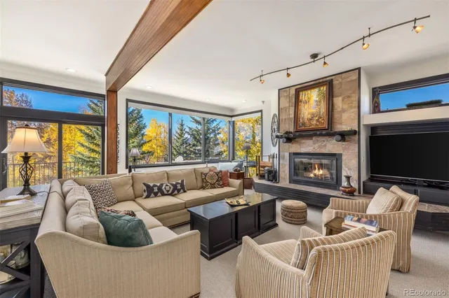 a living room with furniture fireplace and a large window