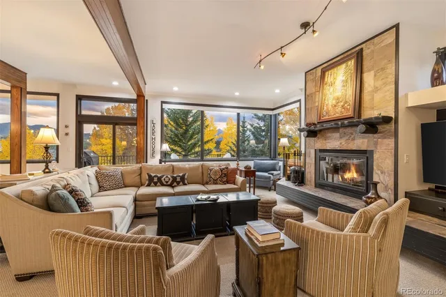 a living room with furniture a flat screen tv and a floor to ceiling window