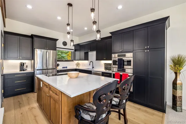 a kitchen with stainless steel appliances granite countertop a stove sink and cabinets