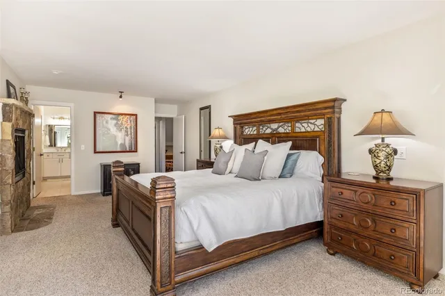 a spacious bedroom with a bed a table and chair