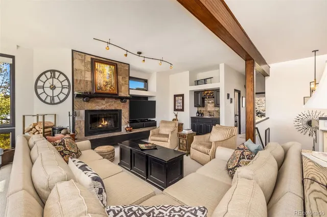 a living room with furniture fireplace and a large window
