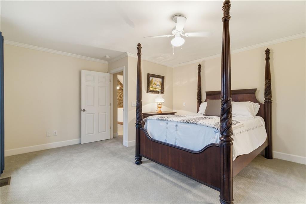 11 Poplar Circle Big Canoe, GA 30143 - Photo 23 of 34 a spacious bedroom with a bed and a chandelier