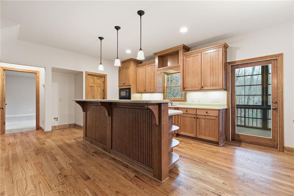 11 Poplar Circle Big Canoe, GA 30143 - Photo 8 of 34 a kitchen with kitchen island granite countertop wooden floors and wide window