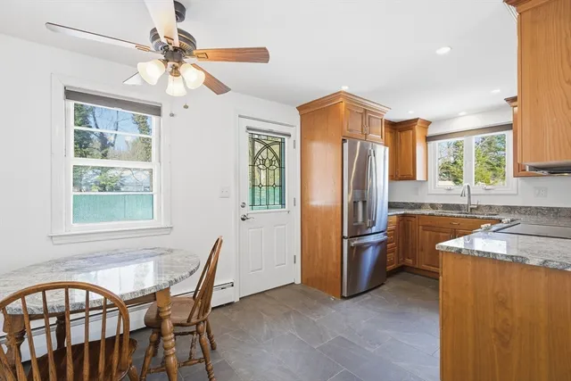 a kitchen with stainless steel appliances granite countertop a refrigerator a sink a stove and island