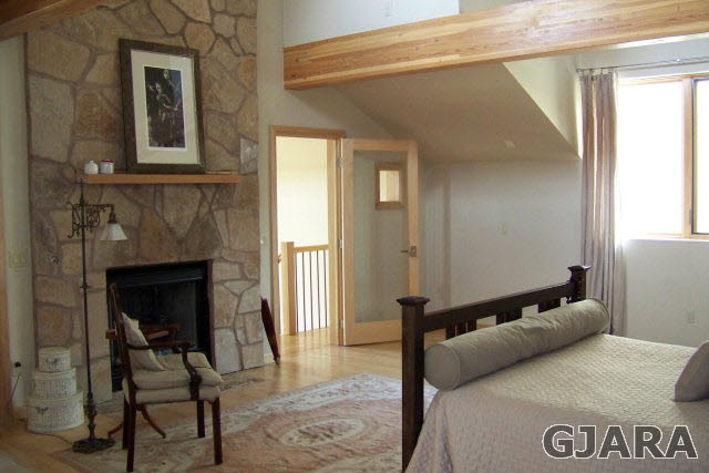 680 39 Road Palisade, CO 81526 - Photo 11 of 32 a bedroom with a bed and a fireplace