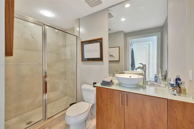 a bathroom with a granite countertop sink toilet and shower