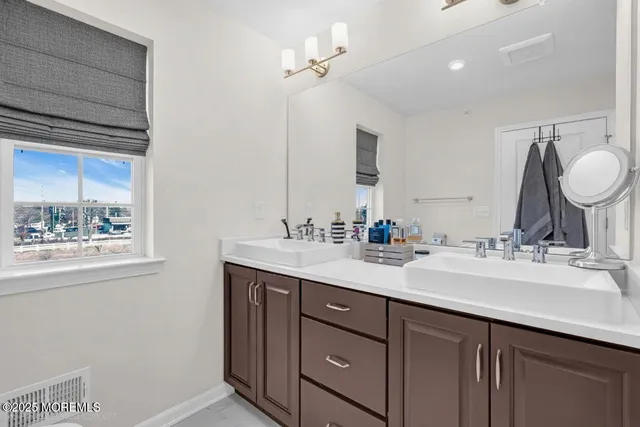 a bathroom with a double vanity sink mirror and shower