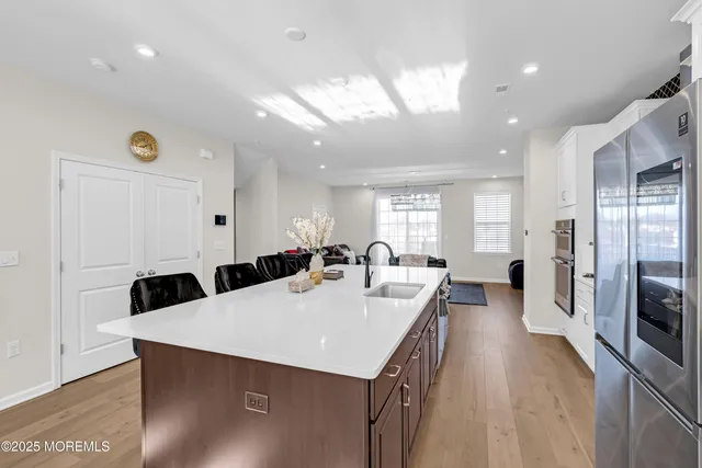a large kitchen with a table chairs refrigerator and cabinets