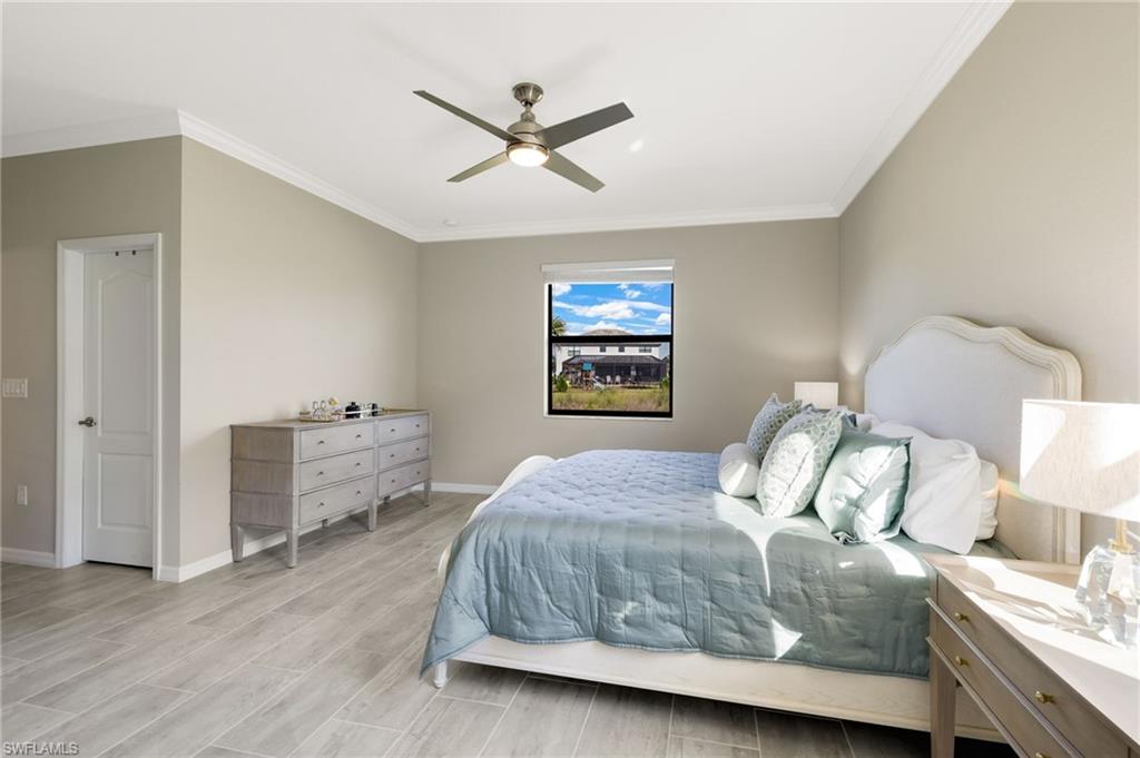 19724 The Pl Boulevard Estero, FL 33928 - Photo 23 of 36 a bedroom with a bed and a chandelier