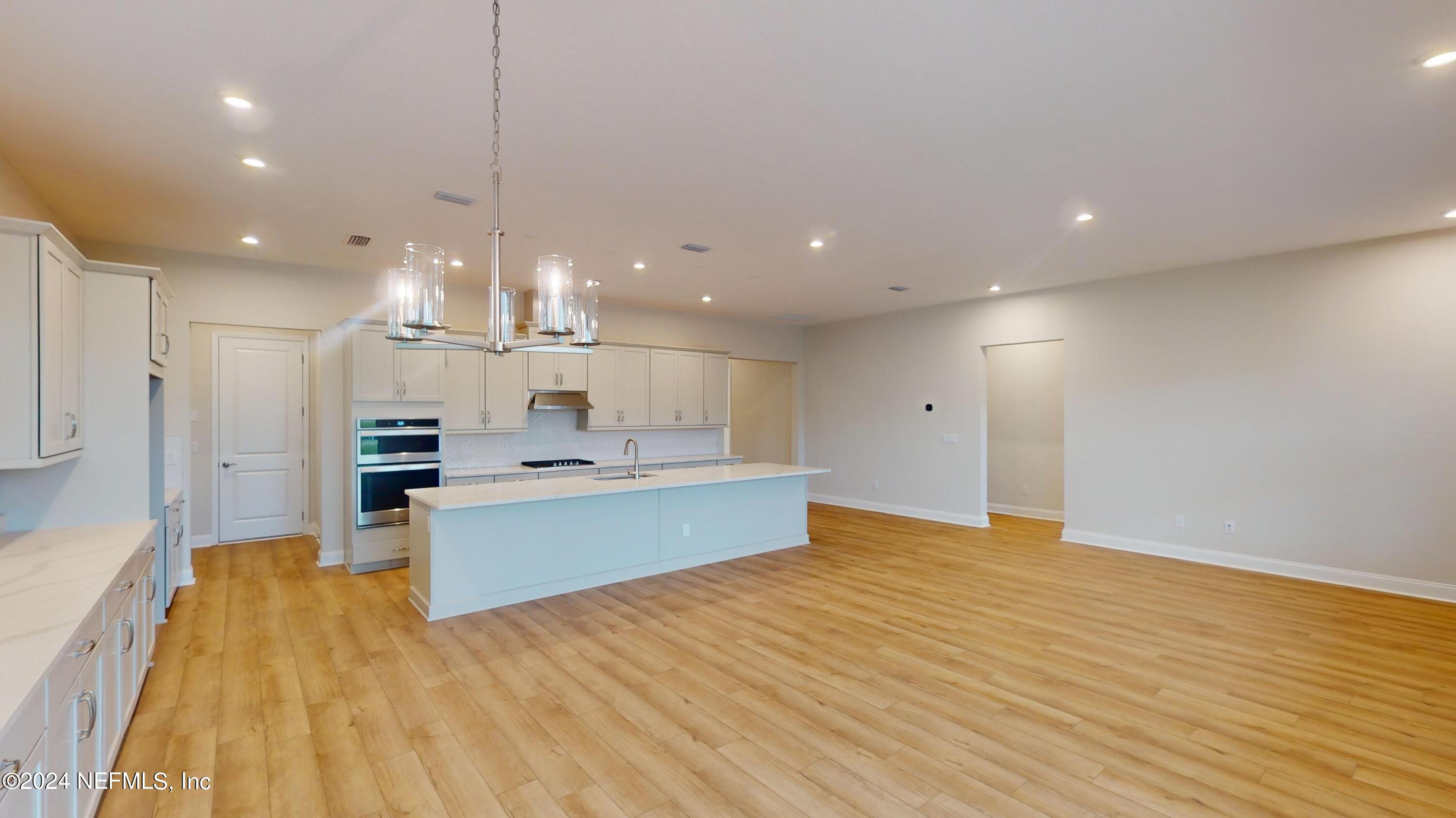 283 Pinellas Way St. Johns, FL 32259 - Photo 15 of 71 a large kitchen with stainless steel appliances a large counter top a chandelier and a wooden floor