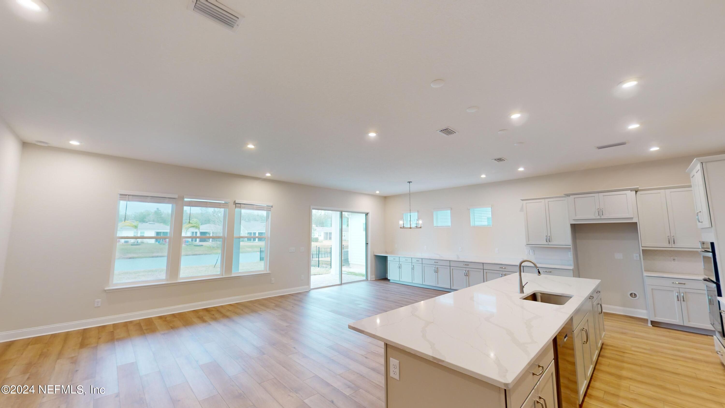 283 Pinellas Way St. Johns, FL 32259 - Photo 16 of 71 a large white kitchen with wooden floor and a large window