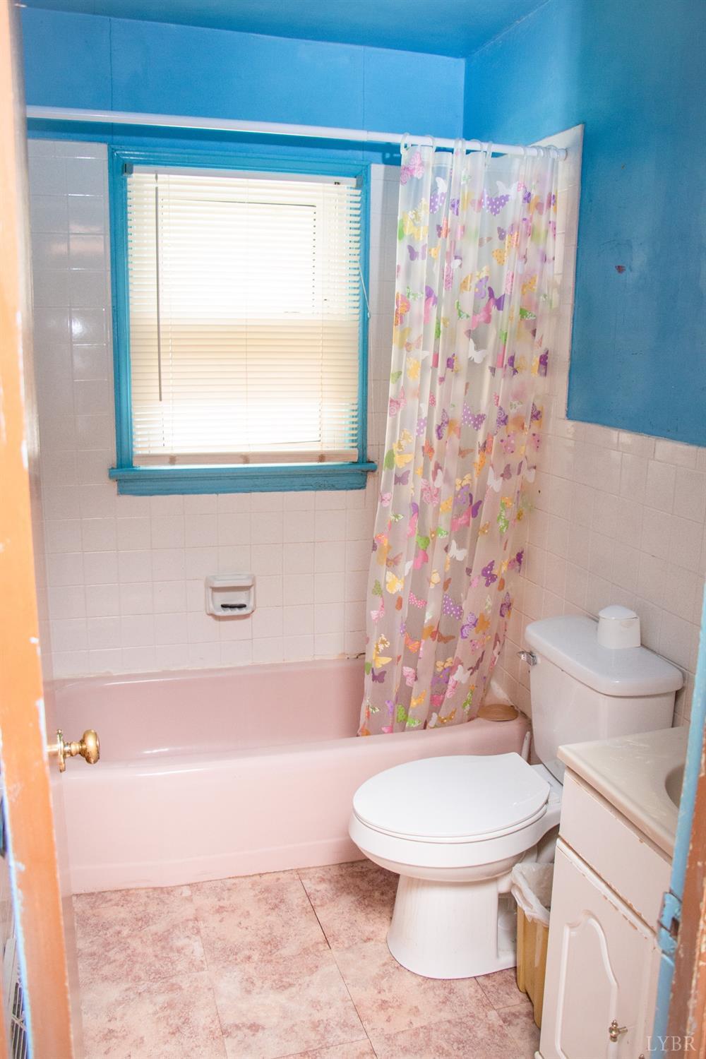 296 Pamplin Road Pamplin, VA 23958 - Photo 12 of 23 a white toilet sitting next to a bathroom sink and a shower