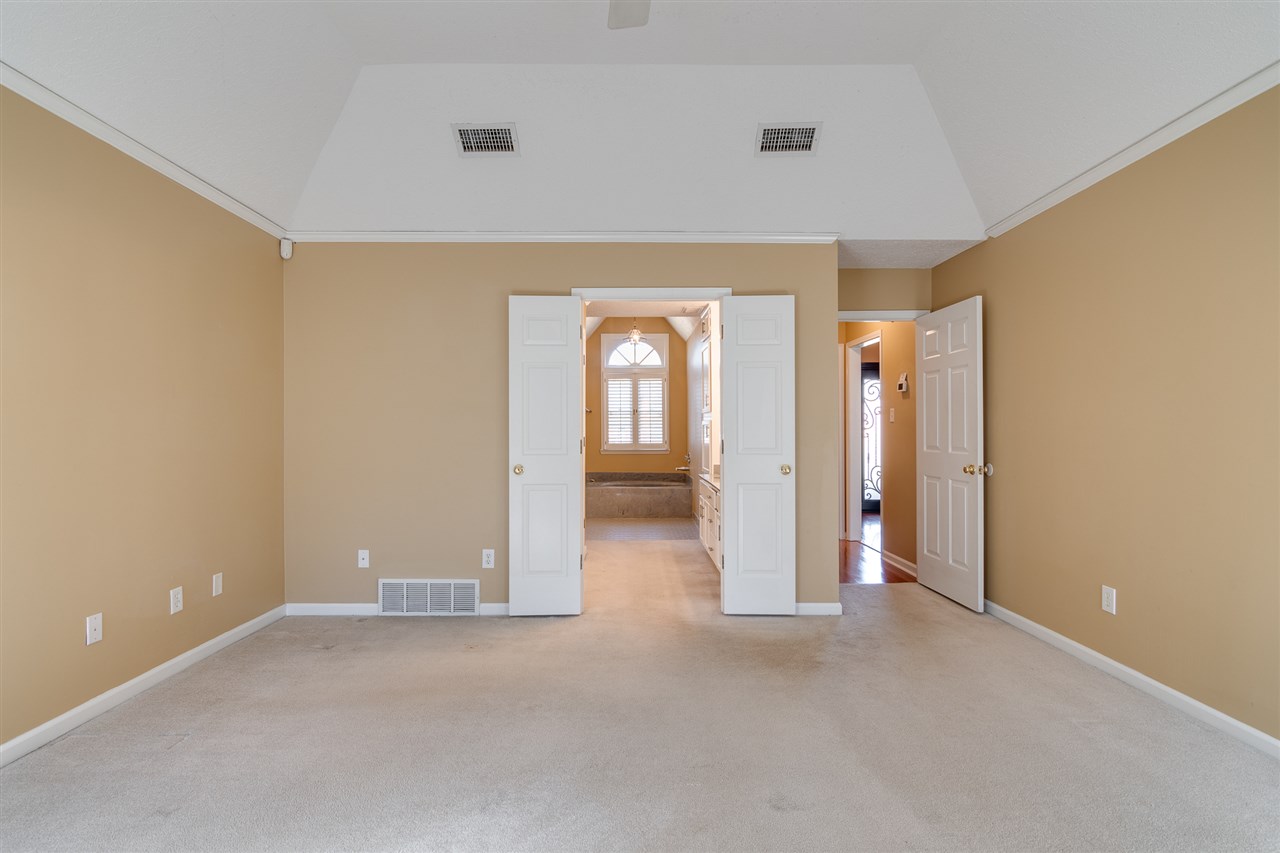 420 Meadvale Road Memphis, TN 38120 - Photo 13 of 25 This view looks through the Primary Bedroom into the en-suite, luxury bath with dual vanity, soaking tub, separate shower, and walk-in closet.