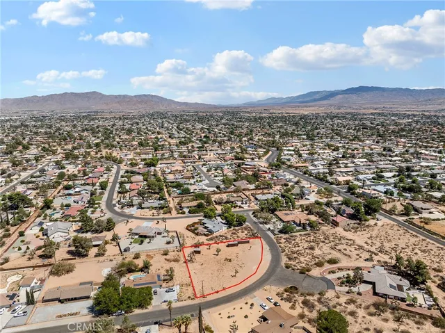 an aerial view of residential houses with outdoor space and trees