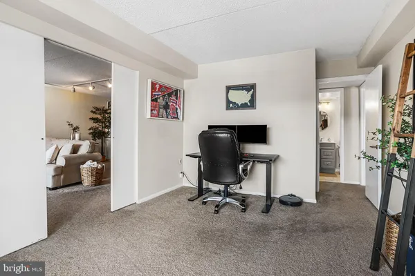 a view of a workspace with furniture and a window