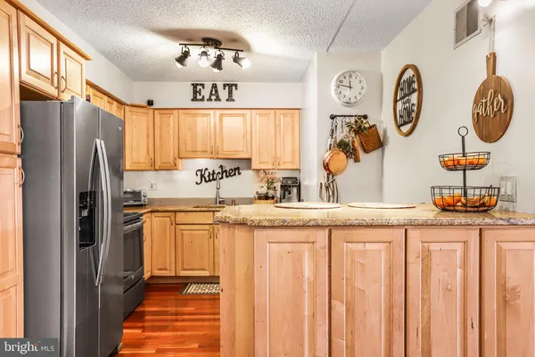 a kitchen with stainless steel appliances granite countertop a sink and a refrigerator
