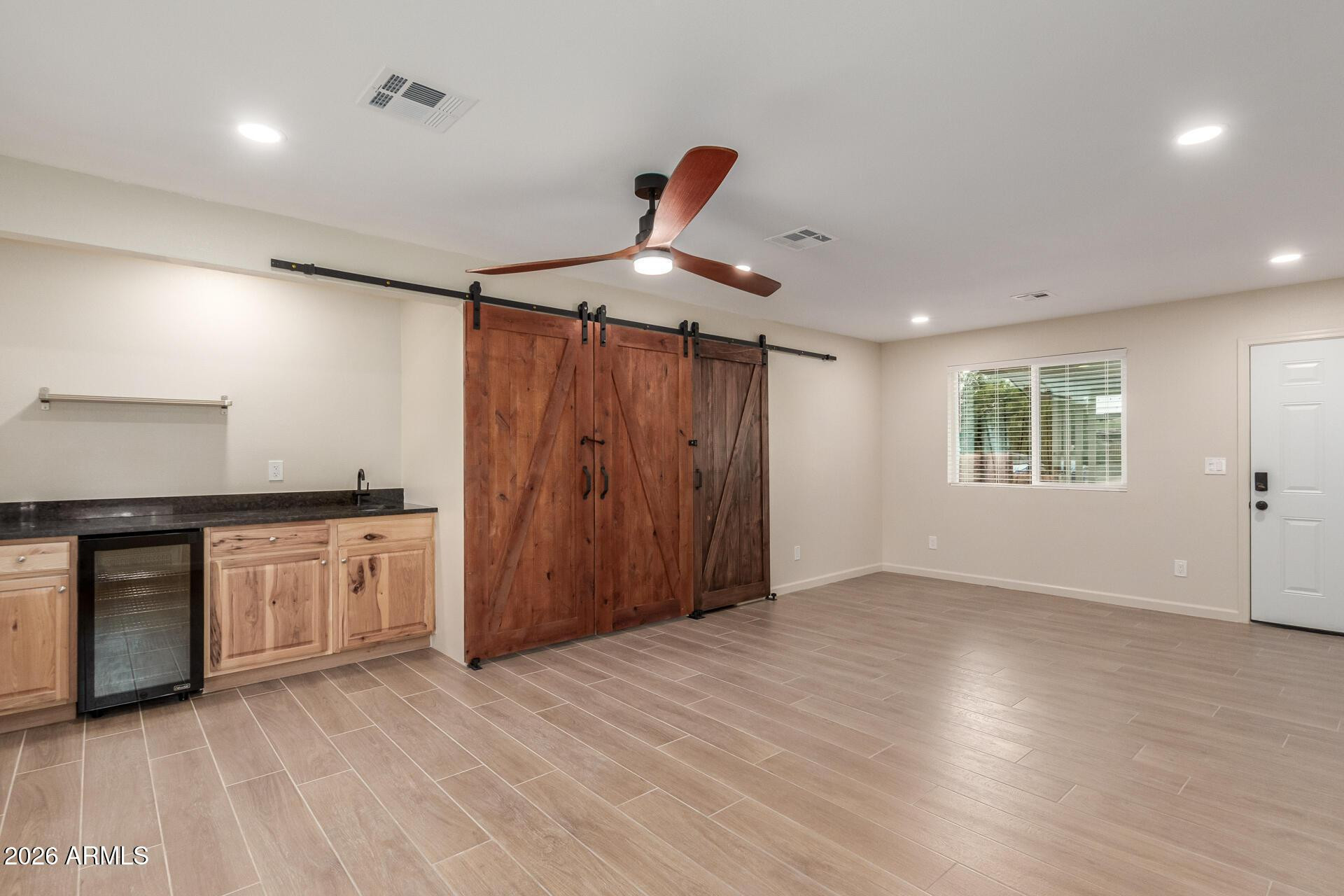 1628 East Del Rio Drive Tempe, AZ 85282 - Photo 9 of 32 an empty room with wooden floor kitchen appliances and windows