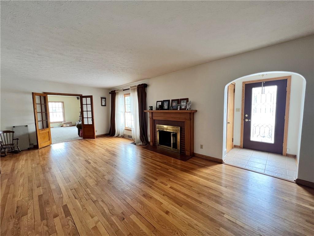2045 Eastbrook Road New Castle, PA 16101 - Photo 2 of 23 an empty room with wooden floor and fireplace