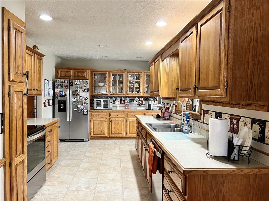 2045 Eastbrook Road New Castle, PA 16101 - Photo 7 of 23 a kitchen with stainless steel appliances a stove top oven a sink a refrigerator and cabinets