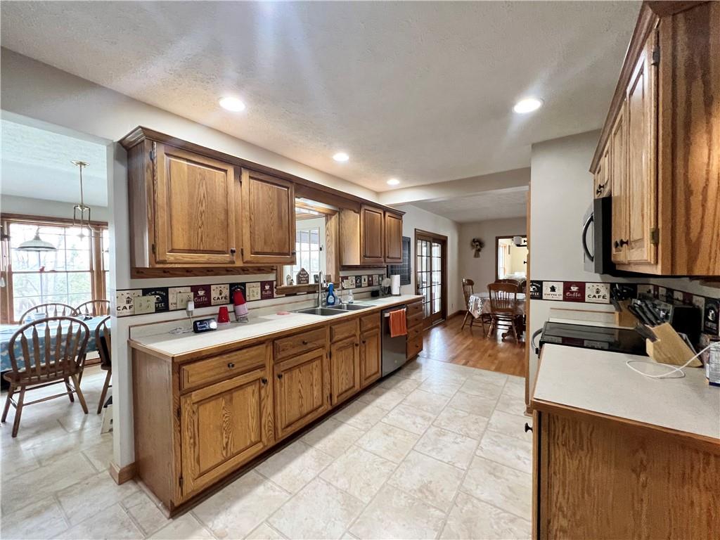 2045 Eastbrook Road New Castle, PA 16101 - Photo 8 of 23 a large kitchen with stainless steel appliances a stove a sink dishwasher and cabinets with wooden floor