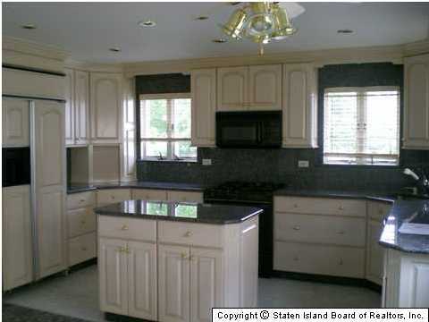 83 Green Valley Road Staten Island, NY 10312 - Photo 2 of 3 a kitchen with stainless steel appliances granite countertop a stove a sink and a microwave
