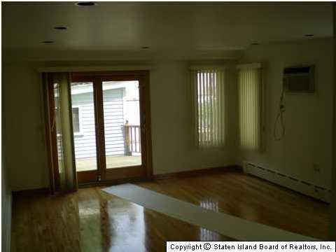 83 Green Valley Road Staten Island, NY 10312 - Photo 3 of 3 a view of an empty room and window