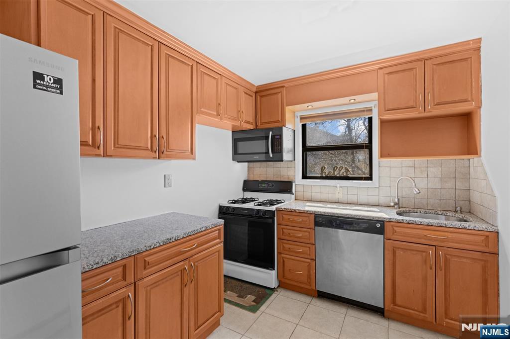 6 Colonial Drive, Unit 6A Little Falls, NJ 07424 - Photo 11 of 44 a kitchen with stainless steel appliances granite countertop a stove sink and microwave