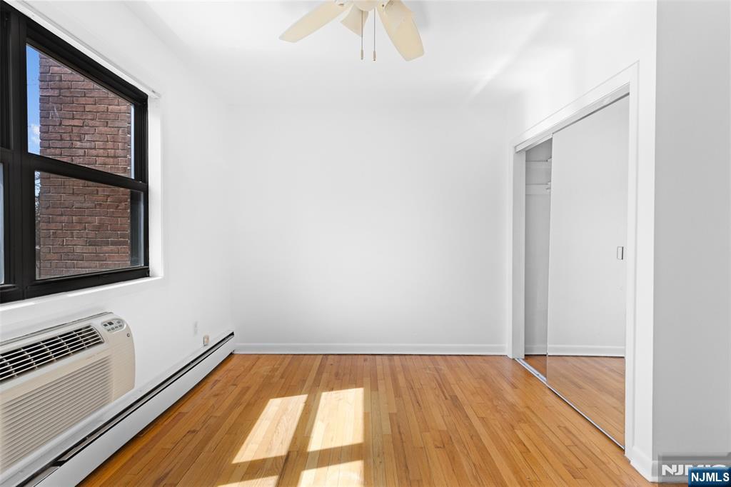 6 Colonial Drive, Unit 6A Little Falls, NJ 07424 - Photo 13 of 44 a view of an empty room with wooden floor and a window