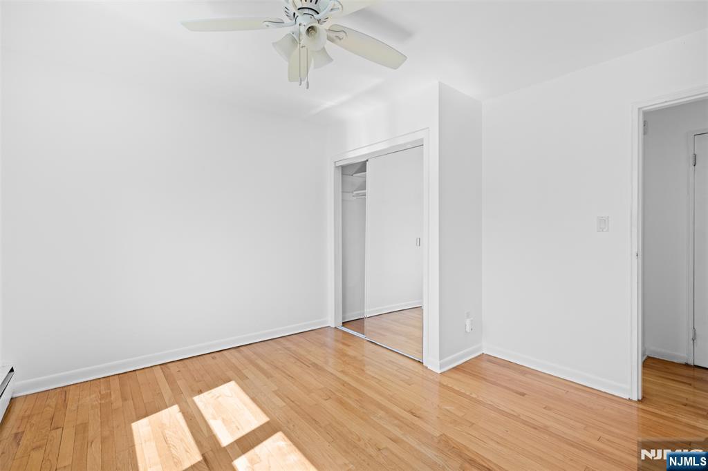 6 Colonial Drive, Unit 6A Little Falls, NJ 07424 - Photo 15 of 44 an empty room with wooden floor fan and windows