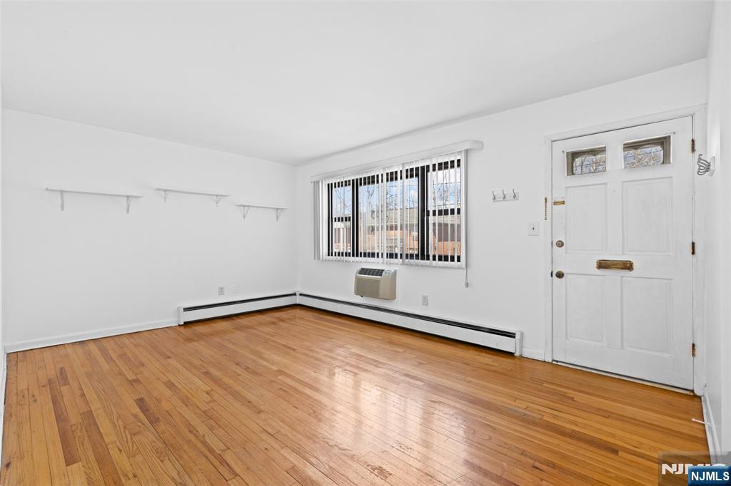 6 Colonial Drive, Unit 6A Little Falls, NJ 07424 - Photo 3 of 44 a view of an empty room with wooden floor and a window